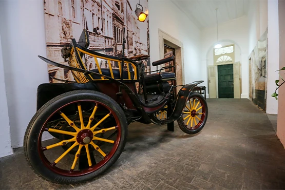 Museu da Misericórdia - Vista do Salão Nobre do Museu com mesa grande e mais de vinte cadeiras de madeira ao redor, teto com telas pintadas a mão e um cristo na cruz ao fundo