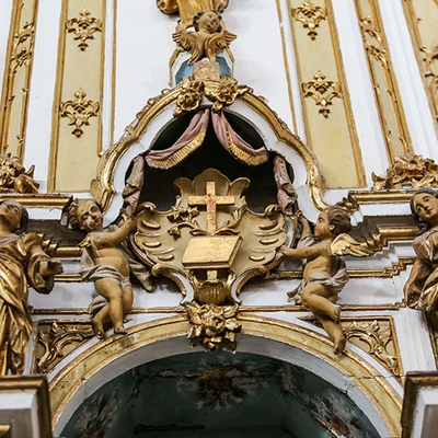 Museu da Misericórdia - Detalhe da decoração do altar da Igreja da Misericórdia com anjos voando e uma cruz ao centro